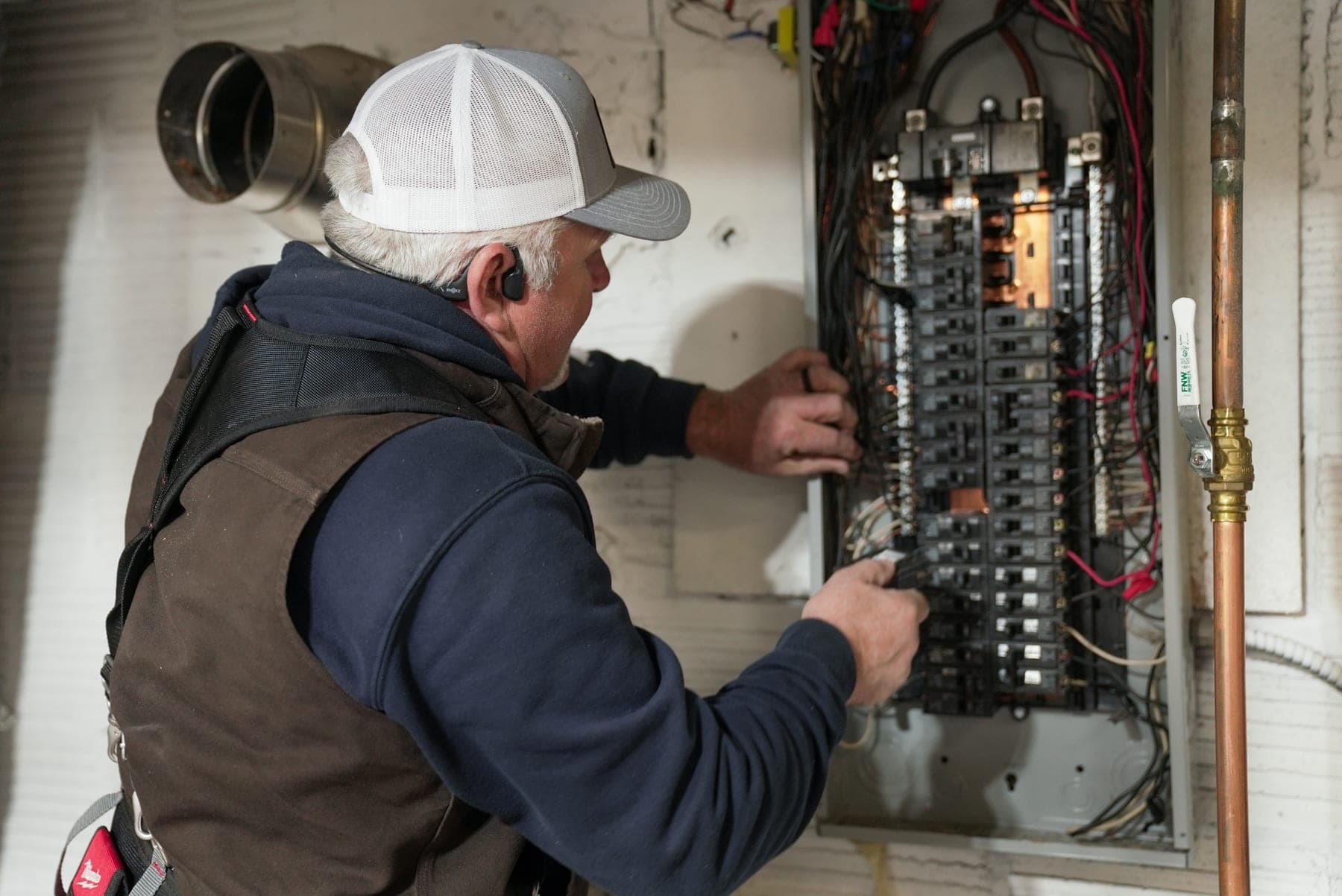 Technician servicing an electrical panel on the job, on-location brand photography by Lenny J Media